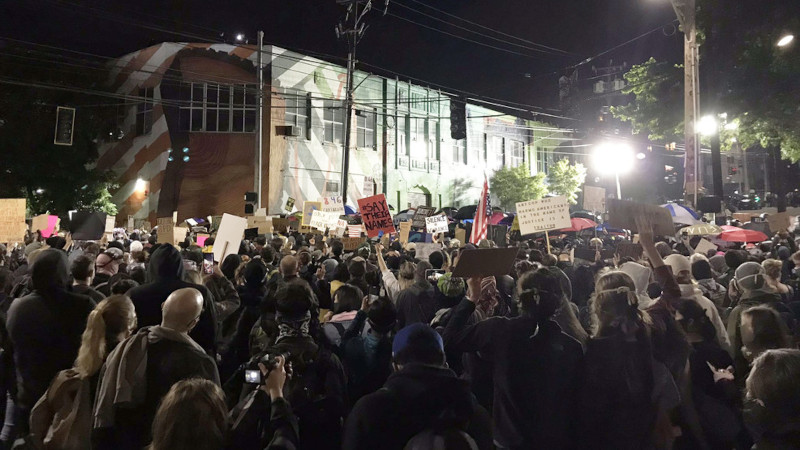 Capitol Hill protest in Seattle at night with various protestors holding signs